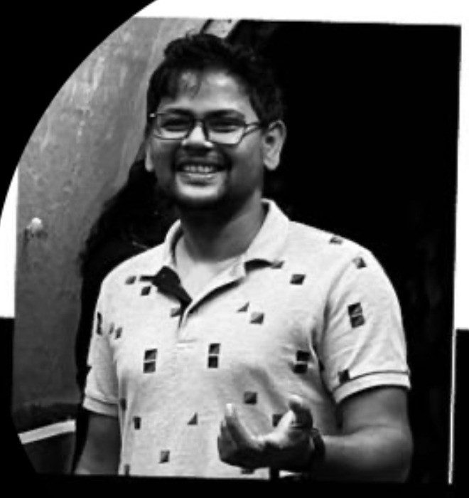 Black and white photo of Amaresh Nayak, smiling, wearing glasses and a patterned polo shirt